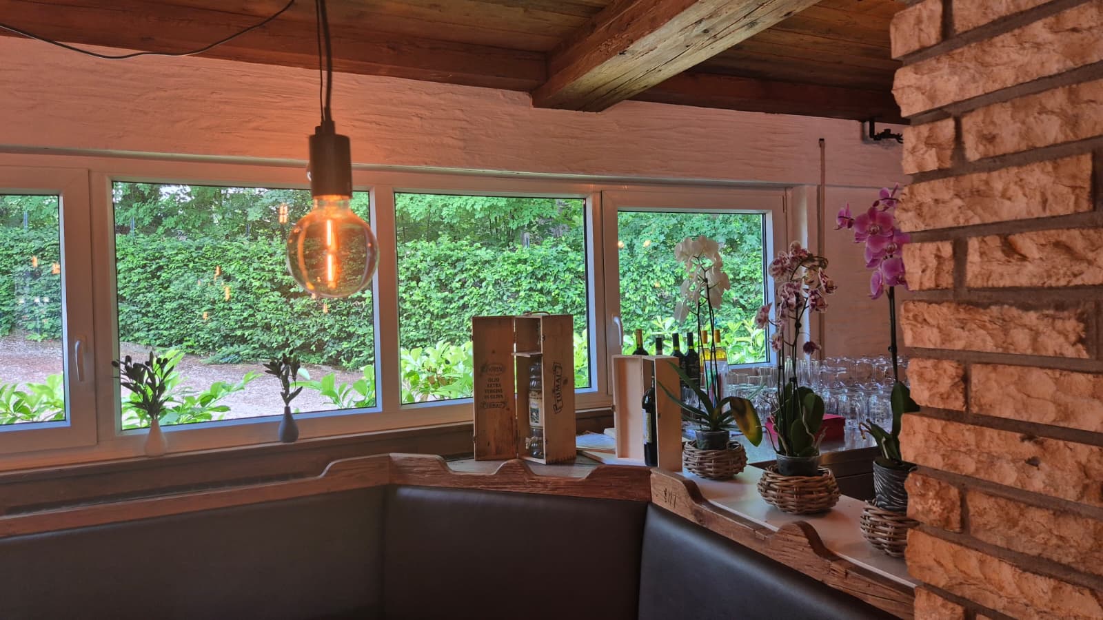 Eckbank am Fenster mit Wein und Orchideen